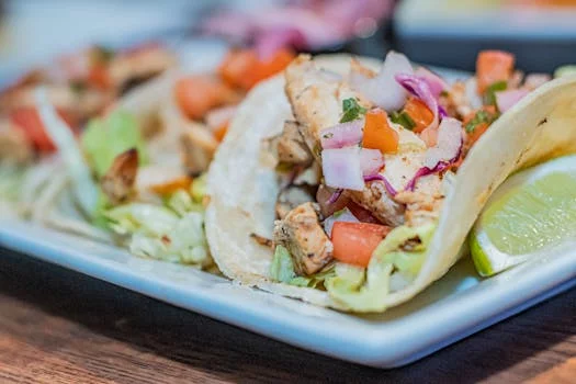 chicken tacos with fresh toppings and lime